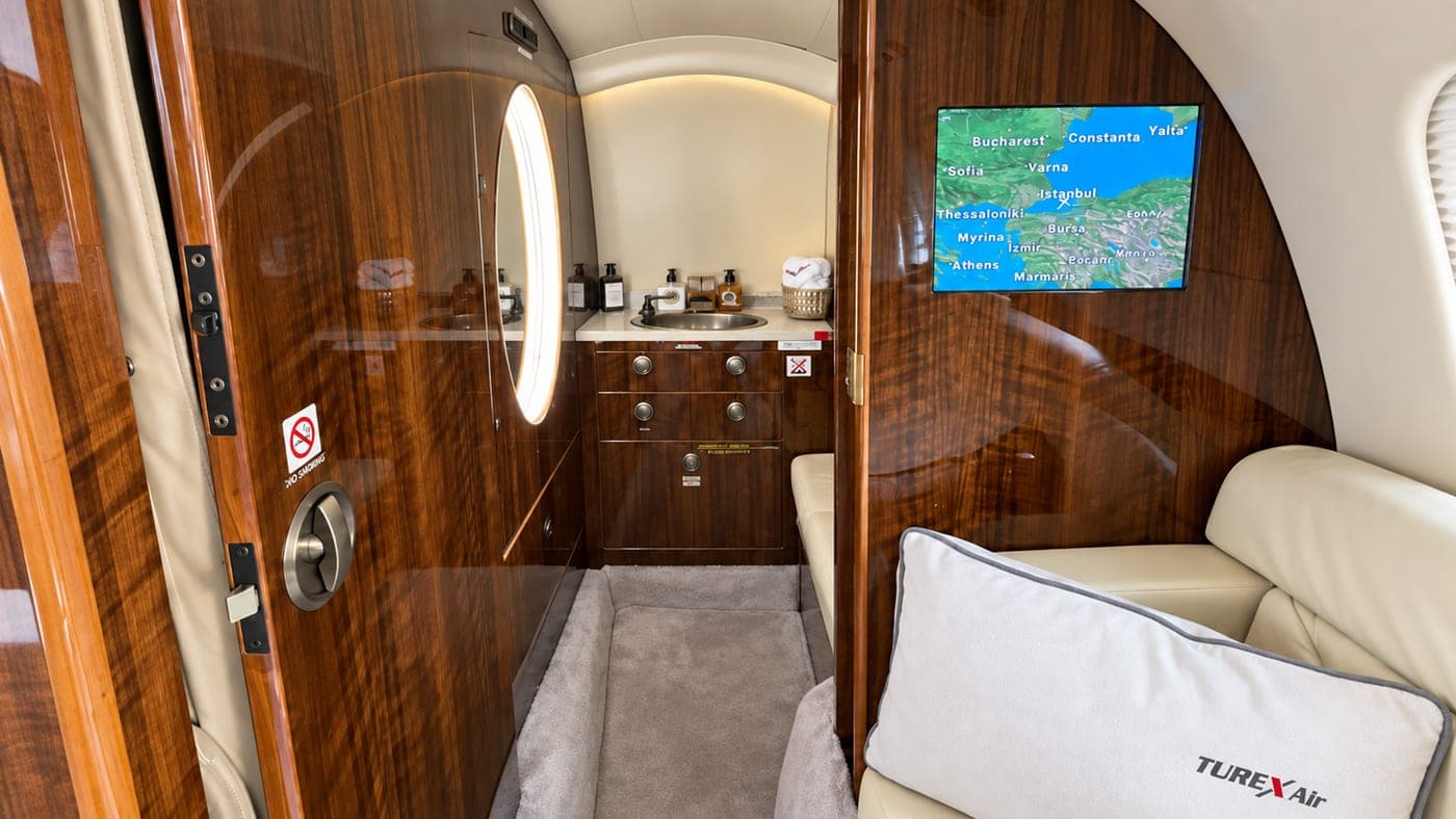 In-cabin moving map screen and the wooden door to the lavatory area